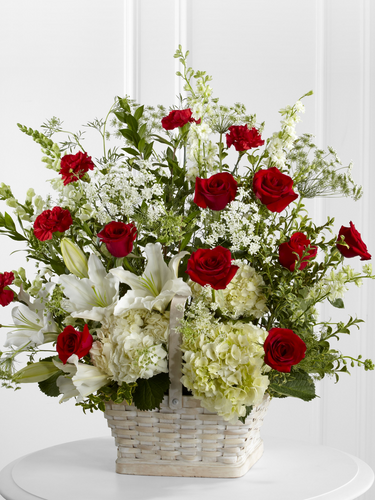 Large red and white funeral basket with roses, lilies, hydrangea and greenery